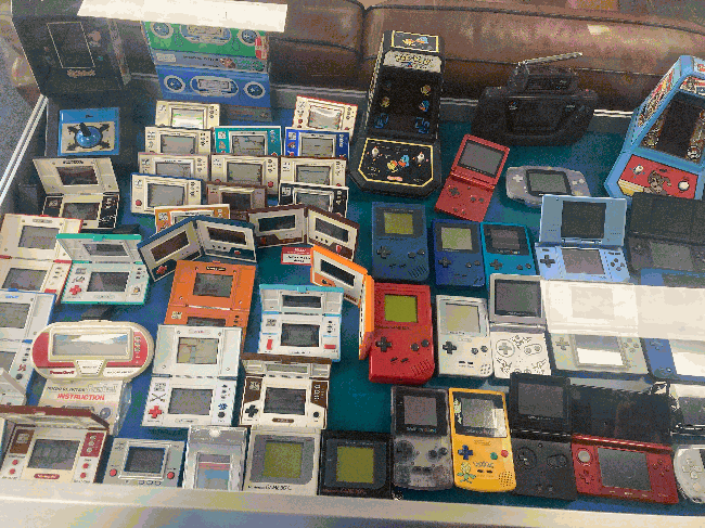 A cabinet full of handheld consoles, mostly Game&Watch consoles, the entire Gameboy family, the DS line along with a red old 3DS